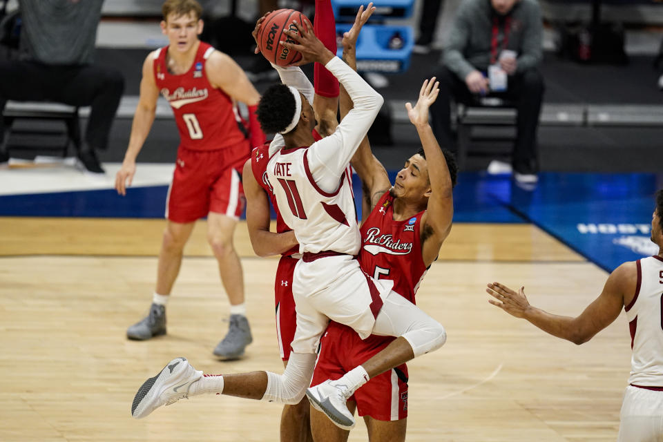 Arkansas guard Jalen Tate (11) shoots over Texas Tech guard Micah Peavy (5) in the first half of a second-round game in the NCAA men's college basketball tournament at Hinkle Fieldhouse in Indianapolis, Sunday, March 21, 2021. (AP Photo/Michael Conroy)