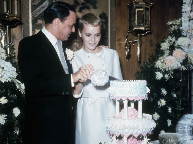 <p>Bettmann</p> Frank Sinatra and Mia Farrow cut their wedding cake at the Sands Hotel following their wedding on July 19, 1966.