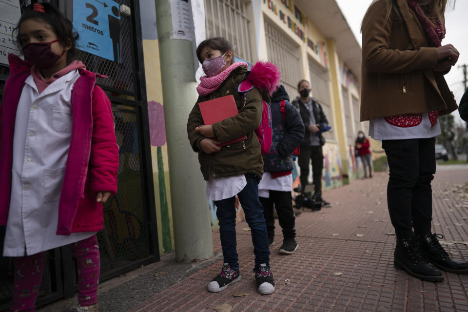 Children stand in line to enter their elementary school in San Martin, a municipality in the Buenos Aires province, Argentina, Wednesday, June 16, 2021. More than 3 million students in the Buenos Aires province resumed in-person classes at all levels Wednesday amid a severe, second wave of the COVID-19 pandemic. (AP Photo/Victor R. Caivano)
