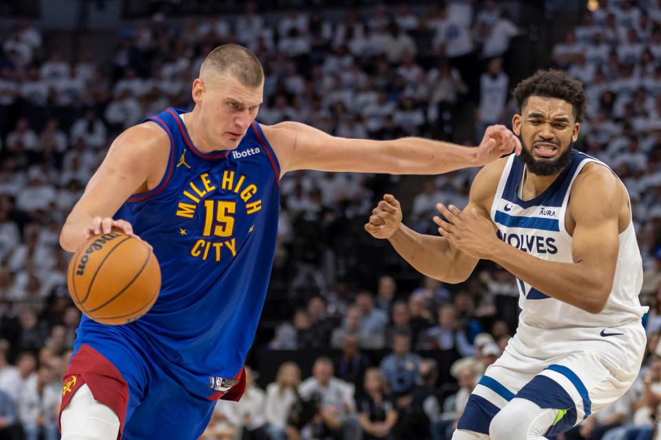 In the first half of Game 3, Denver Nuggets center Nikola Jokic penetrates the basket, beating Minnesota Timberwolves big man Karl-Anthony Towns.