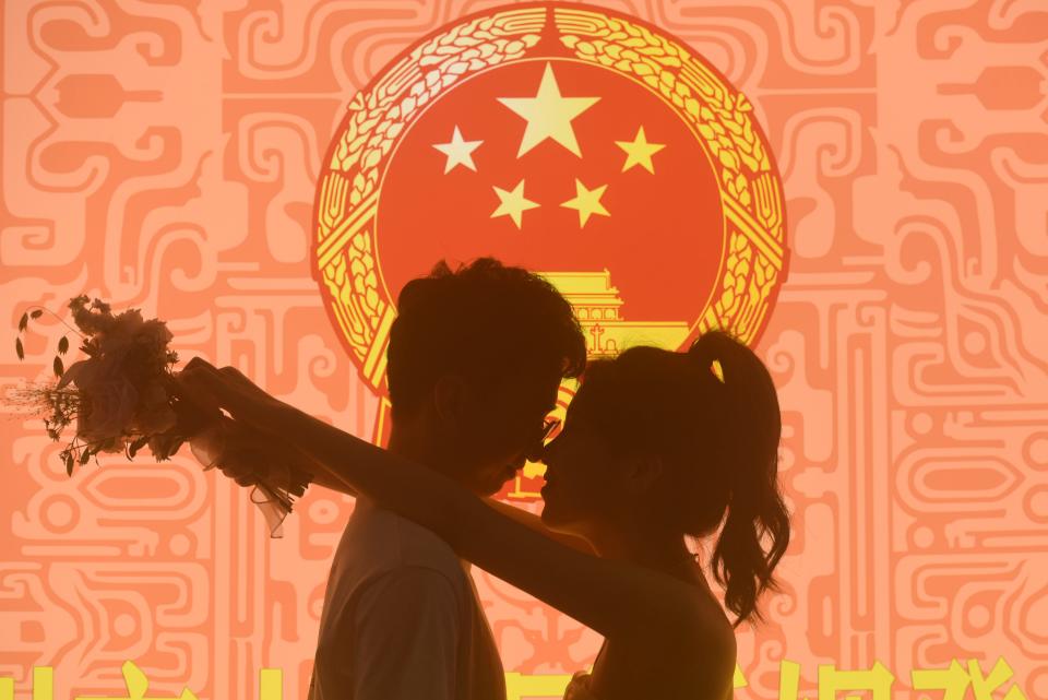 A couple poses for a photo at a marriage registration office in Hangzhou, Zhejiang province, China, Aug 22, 2023.