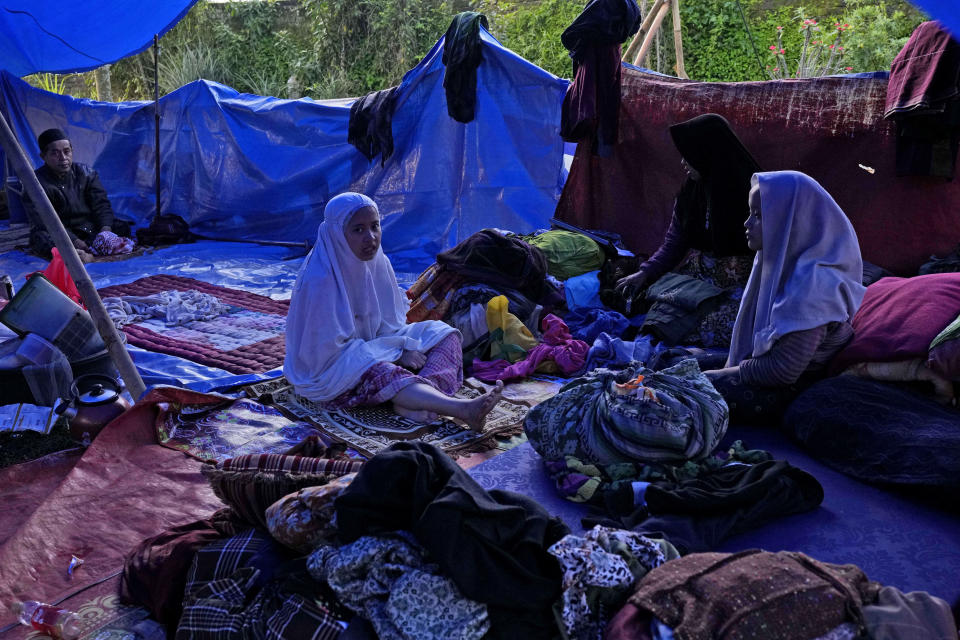 Earthquake survivors sit under a makeshift tent at their temporary shelter in Cianjur, West Java, Indonesia, Thursday, Nov. 24, 2022. The 5.6 magnitude earthquake left hundreds dead, injures and missing as buildings crumbled and terrified residents ran for their lives on Indonesia's main island of Java. (AP Photo/Tatan Syuflana)
