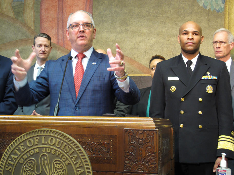 Louisiana Gov. John Bel Edwards speaks about the new coronavirus while U.S. Surgeon General Jerome Adams, right, listens on Thursday, March 12, 2020, in Baton Rouge, La. The number of cases of the COVID-19 disease caused by the virus are on the rise in Louisiana. (AP Photo/Melinda Deslatte)