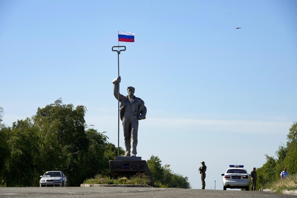 FILE A Russian soldier stands in the road at the entrance of Mariupol with a Soviet style symbolic monument of a metallurgist, on the territory which is under the Government of the Donetsk People's Republic control, eastern Ukraine, Sunday, June 12, 2022. Amid the death and destruction war leaves in its wake, there are powerful dynamics and narratives: domination, besieged populations, occupation and their counterparts, resistance, freedom and liberation. Vast swaths of Western and Eastern Europe and the Soviet Union knew this well at various points of the 20th century. (AP Photo, File)