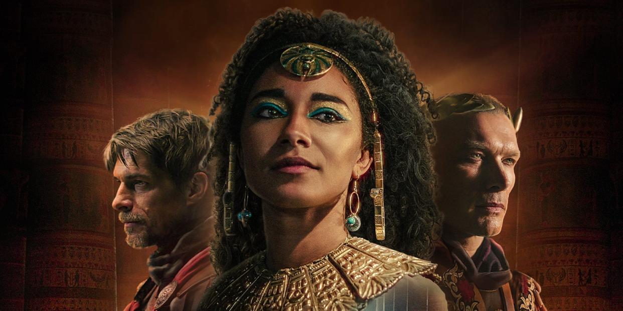 A promotional image for the Netflix series "Queen Cleopatra," showing Adele James in costume with two figures against a dark background.