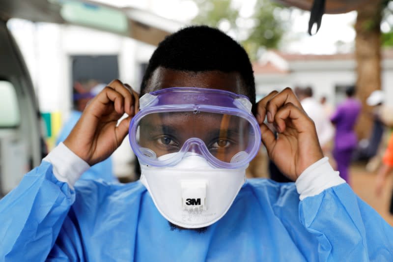 FILE PHOTO: Private ambulance paramedic puts on protective gear during a training in the town of Thika