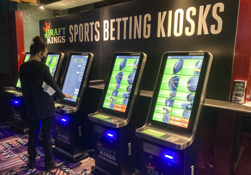 FILE - In this Thursday Sept. 30, 2021, file photo Zach Young, of New Haven, Conn., places a bet at one of the new sports wagering kiosks at Foxwoods Resort Casino in Mashantucket, Conn. Legalized sports betting continued its expansion in 2023 with six states either passing legislation or beginning to accept wagering, Fanatics got into the business and professional leagues and college athletics continued to further embrace the industry. (AP Photo/Susan Haigh, File)