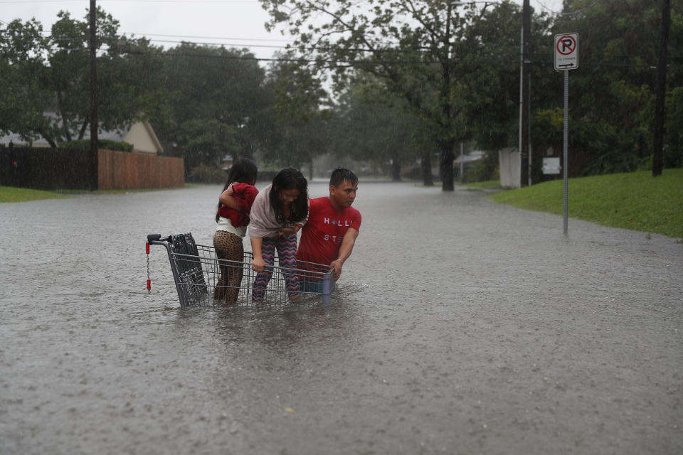 A man helps children across a flooded street in Houston.&nbsp;