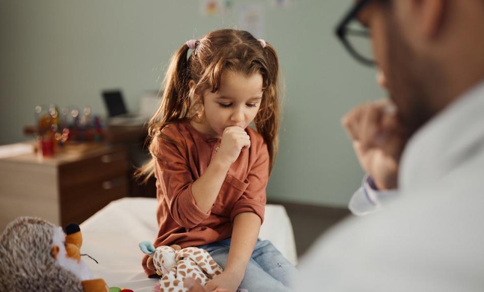 Girl coughing at doctor