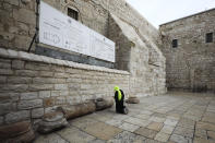 A pilgrim prays outside the Church of the Nativity in Bethlehem, West Bank, Thursday, March 5, 2020. Palestinian authorities said the Church of the Nativity in Bethlehem, built atop the spot where Christians believe Jesus was born, will close indefinitely due to coronavirus concerns. (AP Photo/Mahmoud Illean)