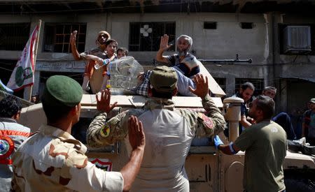 Displaced civilians wave to soldiers after they are rescued by Iraqi security forces at Old City in western Mosul, Iraq June 23, 2017. REUTERS/Erik De Castro