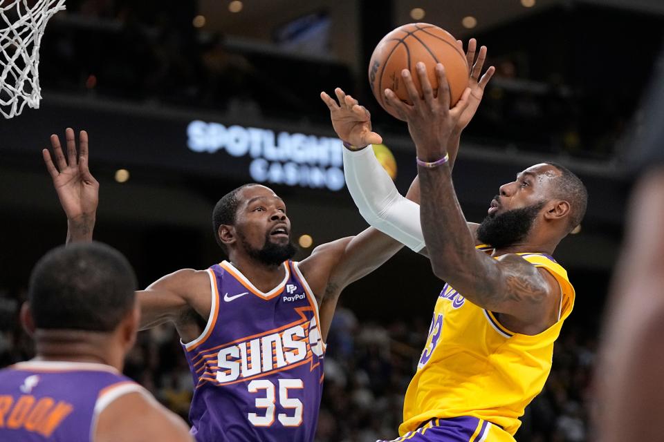 Los Angeles Lakers forward LeBron James (right) shoots and Phoenix Suns forward Kevin Durant defends during the first half of an NBA preseason game in Thousand Palms, California, on October 19, 2023.