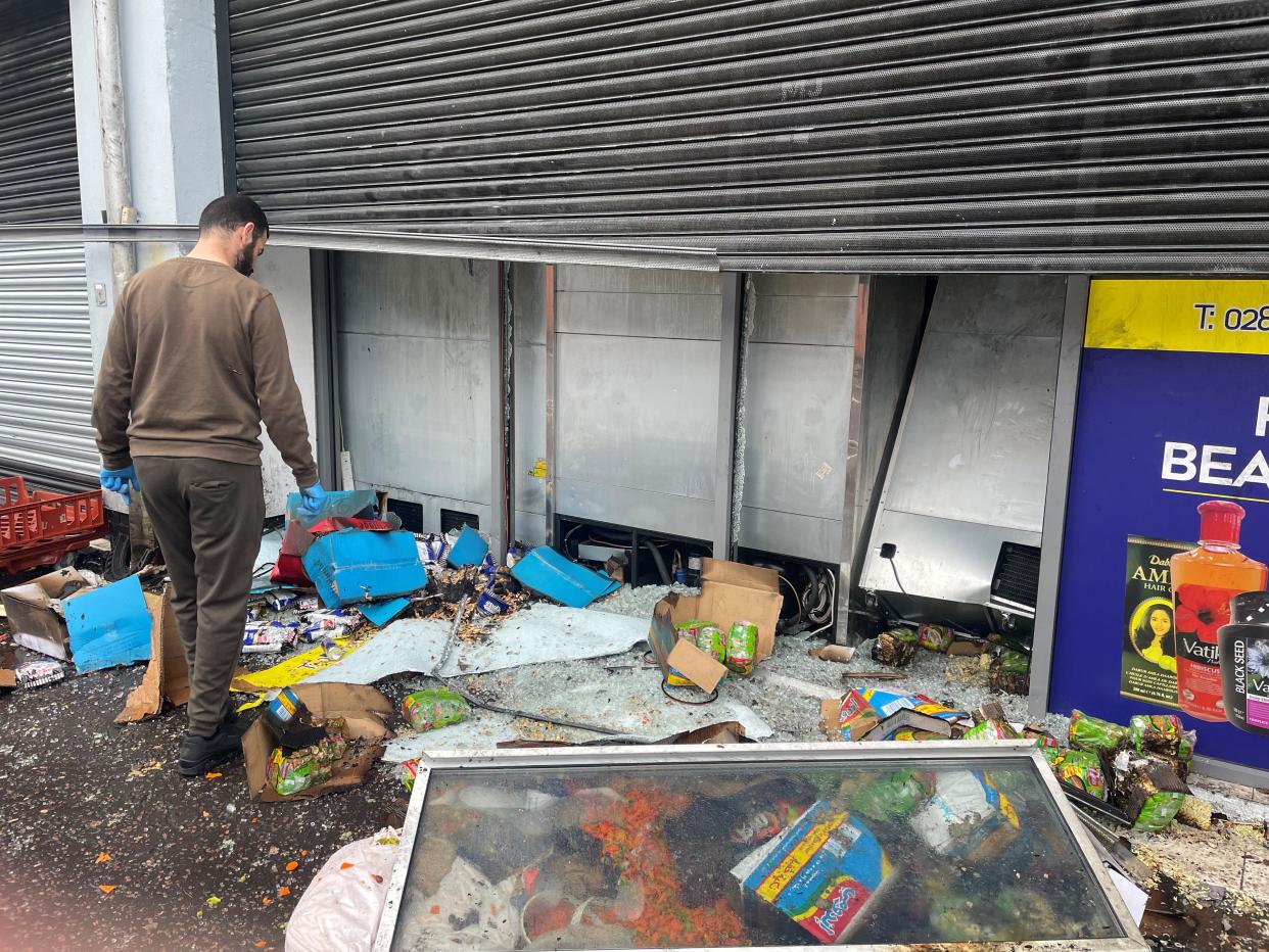 A man inspecting fire damage outside the supermarket