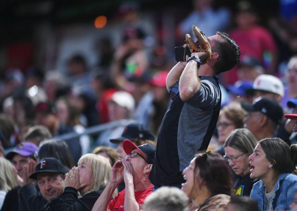 Fans shout after a play as the Fresno Grizzlies played their 2023 home opener against the Stockton Ports Tuesday, April 11, 2023 in Fresno.