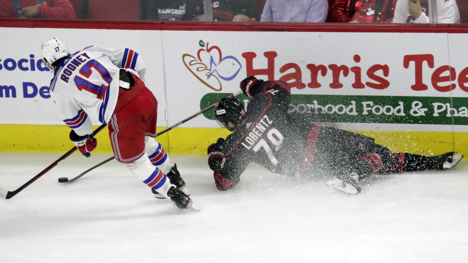 New York Rangers center Kevin Rooney (17) and Carolina Hurricanes center Steven Lorentz (78) go after the puck during the second period during Game 2 of an NHL hockey Stanley Cup second-round playoff series Friday, May 20, 2022, in Raleigh, N.C. (AP Photo/Chris Seward)