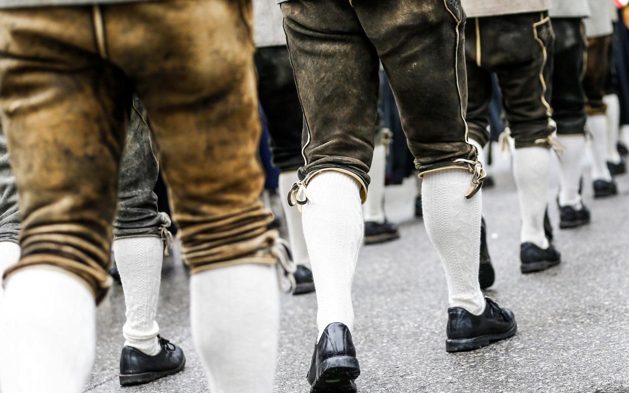 Men in traditional Tyrolean lederhosen march in a parade at a cultural festival in Austria - REUTERS