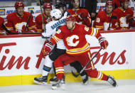 San Jose Sharks' Alexander Barabanov, left, is checked by Calgary Flames' Trevor Lewis during the second period of an NHL hockey game, Tuesday, Nov. 9, 2021 in Calgary, Alberta. (Jeff McIntosh/The Canadian Press via AP)