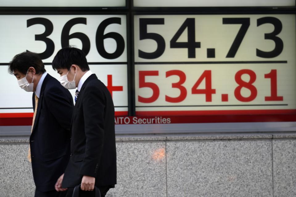 People walk in front of an electronic stock board showing Japan's Nikkei 225 index at a securities firm Thursday, Feb. 8, 2024, in Tokyo. (AP Photo/Eugene Hoshiko)