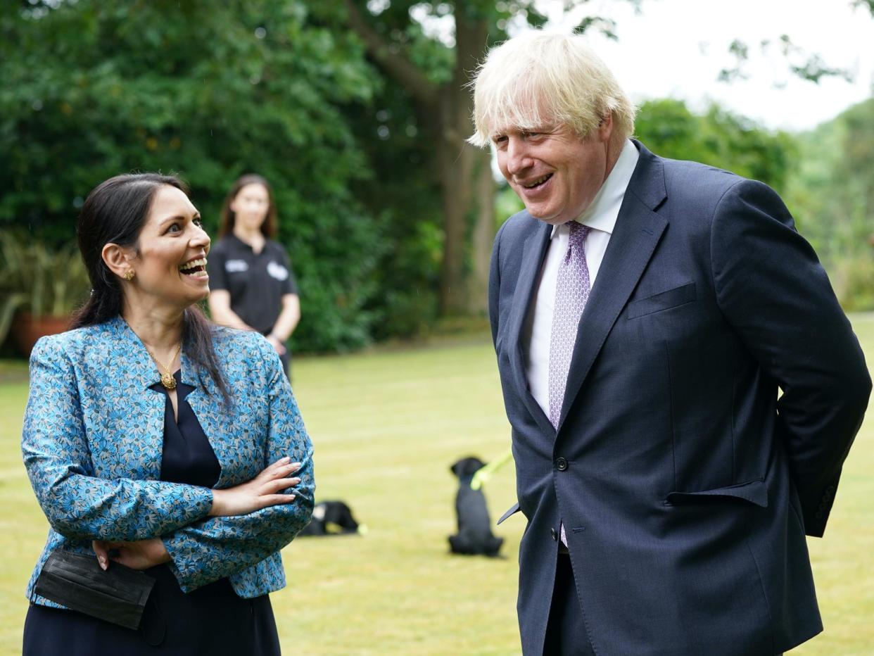 Boris Johnson and his home secretary, Priti Patel, at Surrey Police headquarters on Tuesday (PA)