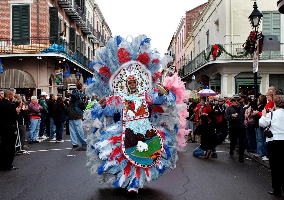 FILE - In this Jan. 1, 2008 file photo, "Big Chief" Alfred Doucette, dances in a parade on Royal Street in the French Quarter of New Orleans. When the Mardi Gras Indians take to the street the elaborate beads and waving feathers will stop traffic and start the cameras clicking. Mardi Gras Indians have historically been Black, though a handful of white people have been involved. (AP Photo/Judi Bottoni, File)