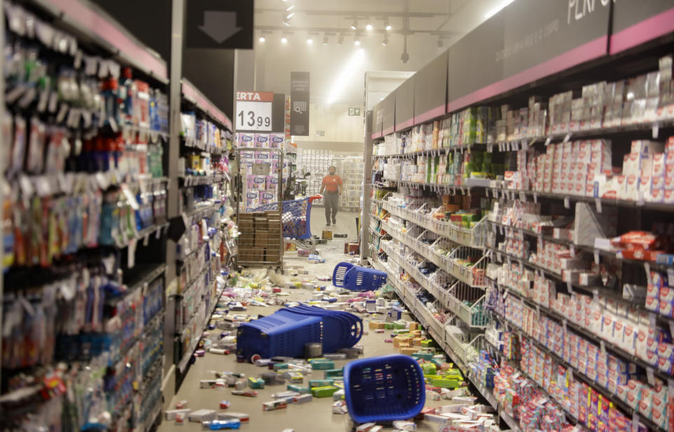 Products knocked off shelves by protesters litter an aisle at a Carrefour supermarket during a protest against the murder of Black man Joao Alberto Silveira Freitas at a different Carrefour supermarket the night before, on Brazil's National Black Consciousness Day in Sao Paulo, Brazil, Friday, Nov. 20, 2020. Freitas died after being beaten by supermarket security guards in the southern Brazilian city of Porto Alegre, sparking outrage as videos of the incident circulated on social media. (AP Photo/Andre Penner)