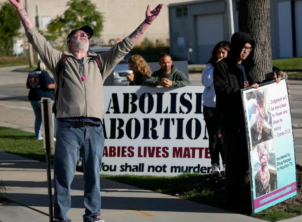 Brian Zysk, an abortion rights advocate, stands alone amid abortion opponents outside Planned Parenthood's Water Street Health Center in Milwaukee.