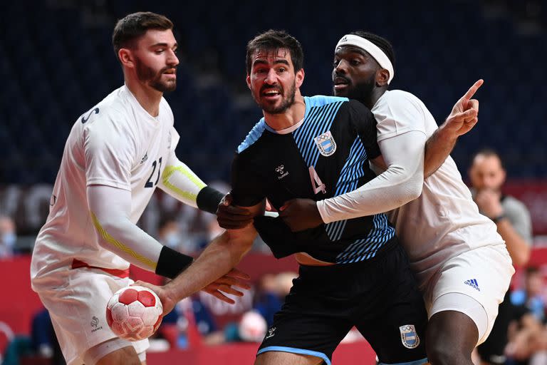 El central argentino Sebastian Simonet (C) es desafiado por el pivote francés Ludovic Fábregas (L) y el lateral derecho francés Dika Mem durante el partido de balonmano del grupo A de la ronda preliminar masculina entre Francia y Argentina de los Juegos Olímpicos de Tokio 2020 en el Estadio Nacional Yoyogi en Tokio. el 24 de julio de 2021.