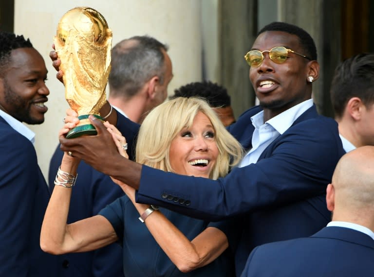 Brigitte Macron and midfielder Paul Pogba hold the World Cup trophy at the Elysee Palace