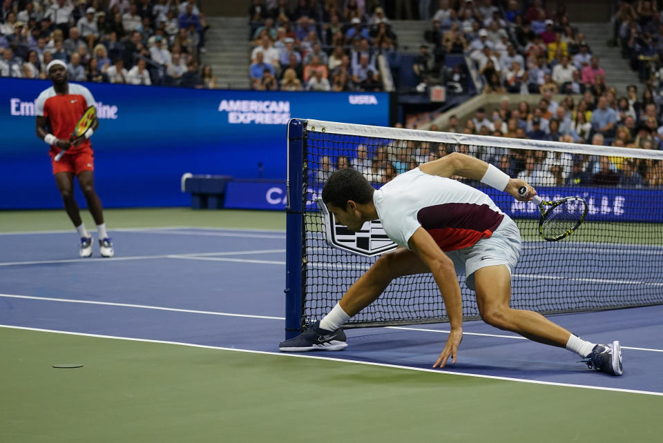 Carlos Alcaraz, of Spain, makes an off-balance shot to Frances Tiafoe, of the United States, during the semifinals of the U.S. Open tennis championships, Friday, Sept. 9, 2022, in New York. (AP Photo/Charles Krupa)