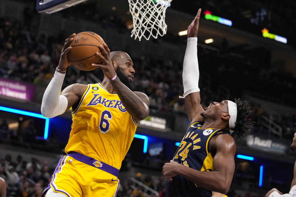 Los Angeles Lakers forward LeBron James (6) looks to pass over Indiana Pacers guard Buddy Hield (24) during the first half of an NBA basketball game in Indianapolis, Thursday, Feb. 2, 2023. (AP Photo/Michael Conroy)