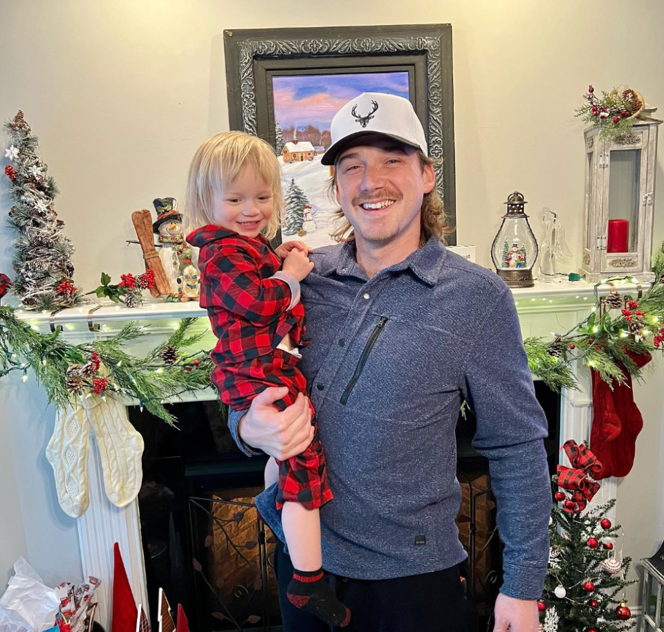 Morgan Wallen holds his son Indigo in front of Christmas decorations