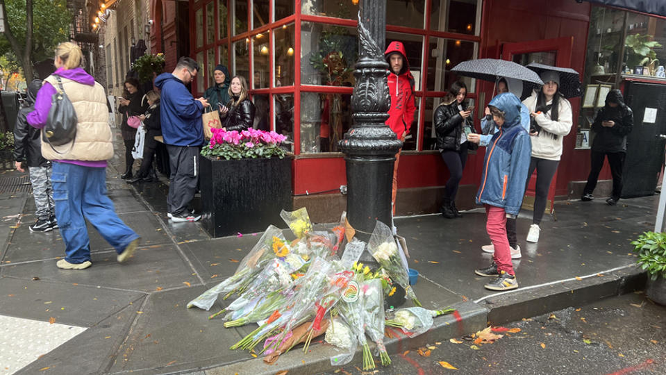 Fans pay tribute to Matthew Perry outside apartment from “Friends.”