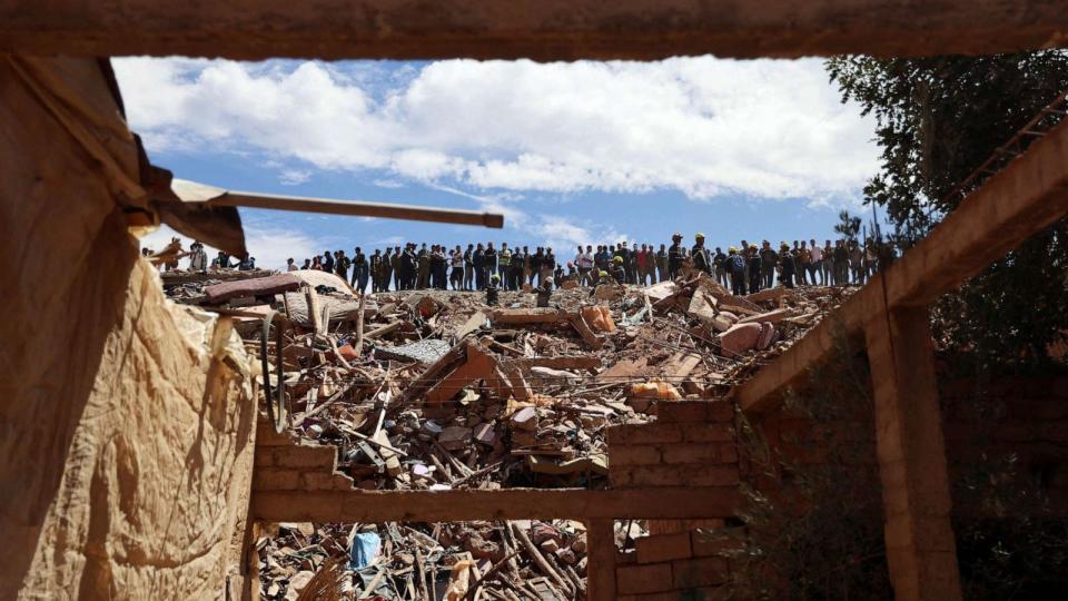 PHOTO: People watch as firefighters work on the rubble in the aftermath of a deadly earthquake in Tallat n'Yakoub, Morocco, Sept. 12, 2023. (Nacho Doce/Reuters)