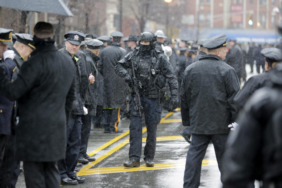 Police officers and other first responders gather in the rain before the funeral of Jersey City Police Detective Joseph Seals in Jersey City, N.J., Tuesday, Dec. 17, 2019. Funeral services for Seals are scheduled for Tuesday morning. The 40-year-old married father of five was killed in a confrontation a week ago with two attackers who then drove to a kosher market and killed three people inside before dying in a lengthy shootout with police. (AP Photo/Seth Wenig)
