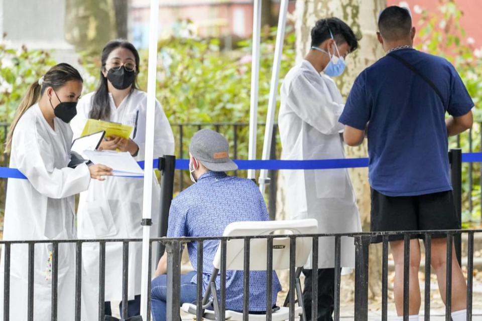 Healthcare workers with New York City Department of Health and Mental Hygiene help people register for the monkeypox vaccine at one of the City’s vaccination sites, Tuesday, July 26, 2022, in New York. (AP Photo/Mary Altaffer)