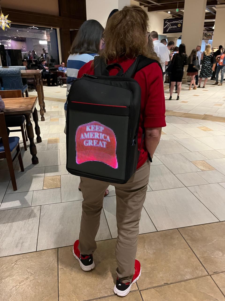 A CPAC attendee carried a backpack with a virtual screen celebrating MAGA.