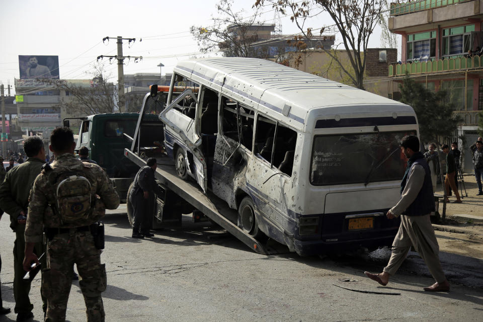 Security personnel remove a damaged minibus after a bomb explosion in Kabul Afghanistan, Thursday, March 18, 2021. The bus attack caused numerous deaths and injuries according to police. (AP Photo/Mariam Zuhaib)
