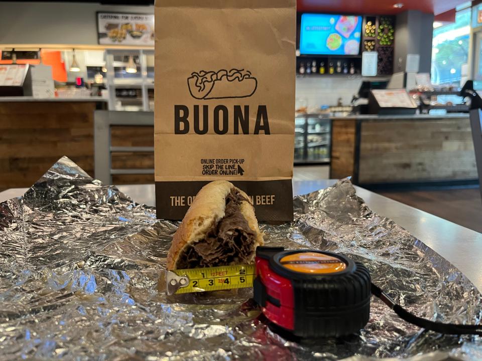 A tape measure next to a Buona Italian beef sandwich, measuring 2 inches in width.