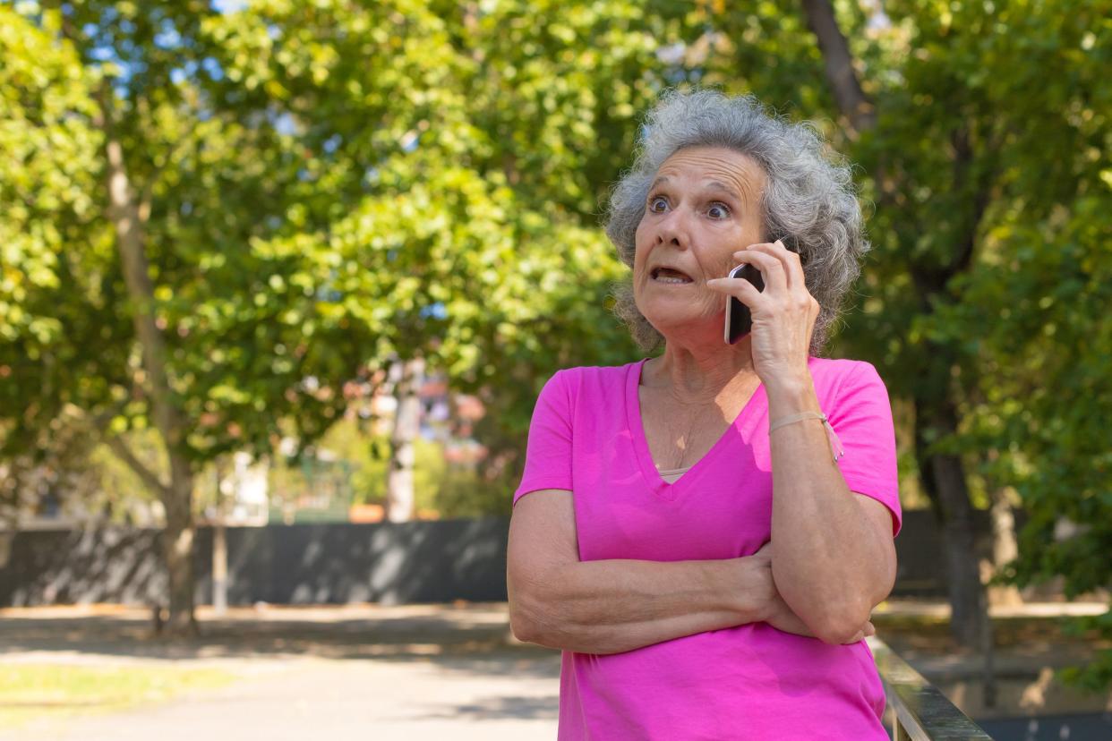 excited surprised old lady getting shocking news from phone call