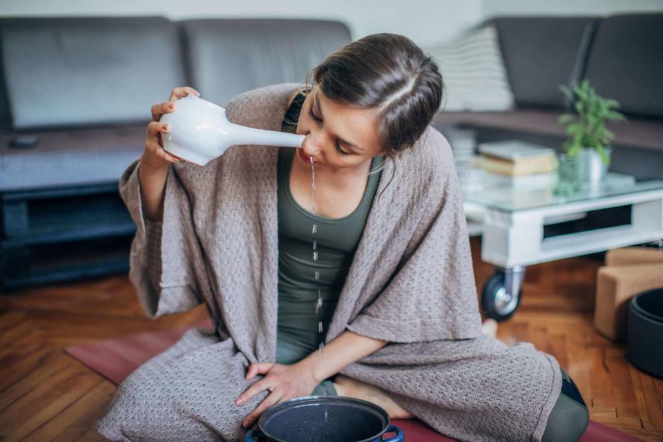 <p>Getty</p> Stock image of woman using a neti pot.