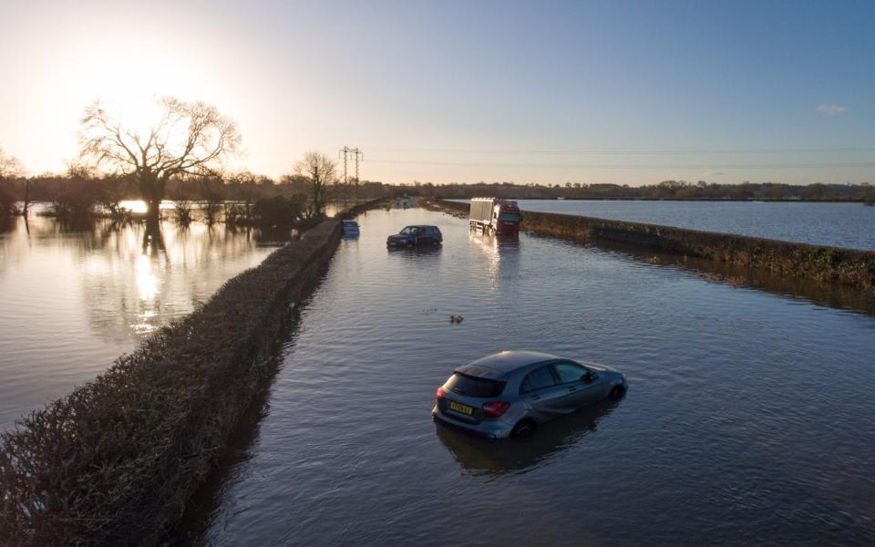 Vehicles remain stranded in the early morning sun by the River Dee 