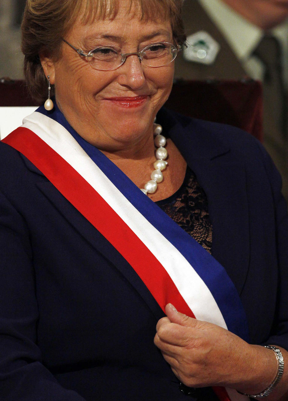 Chile's new President Michelle Bachelet adjusts her presidential sash during a religious ceremony in Santiago, Chile, Wednesday, March 12, 2014. Bachelet, who led Chile from 2006-2010, was sworn-in as president on Tuesday. (AP Photo/Luis Hidalgo)