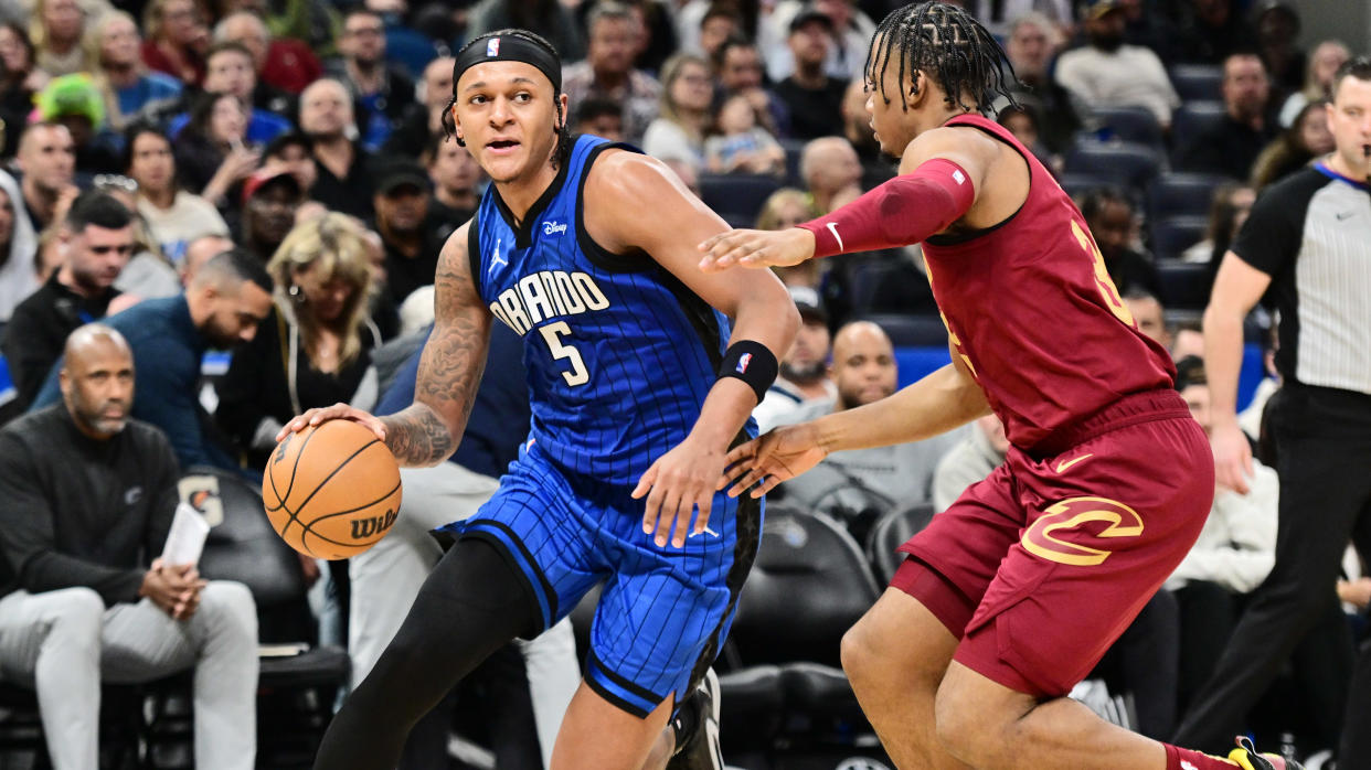 ORLANDO, FLORIDA - DECEMBER 11: Paolo Banchero #5 of the Orlando Magic drives to the net against Isaac Okoro #35 of the Cleveland Cavaliers in the second half of a game at Amway Center on December 11, 2023 in Orlando, Florida. NOTE TO USER: User expressly acknowledges and agrees that, by downloading and or using this photograph, User is consenting to the terms and conditions of the Getty Images License Agreement. (Photo by Julio Aguilar/Getty Images)