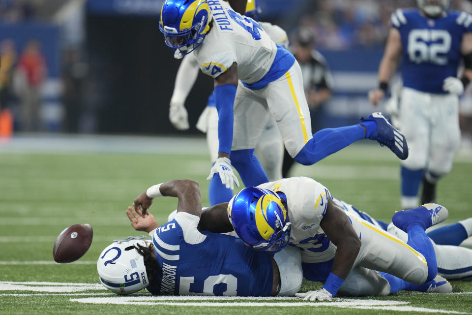 Indianapolis Colts quarterback Anthony Richardson, below, left, fumbles the ball after being hit by Los Angeles Rams safety Jordan Fuller, above, and linebacker Ernest Jones, left, during the first half of an NFL football game, Sunday, Oct. 1, 2023, in Indianapolis. (AP Photo/Michael Conroy)