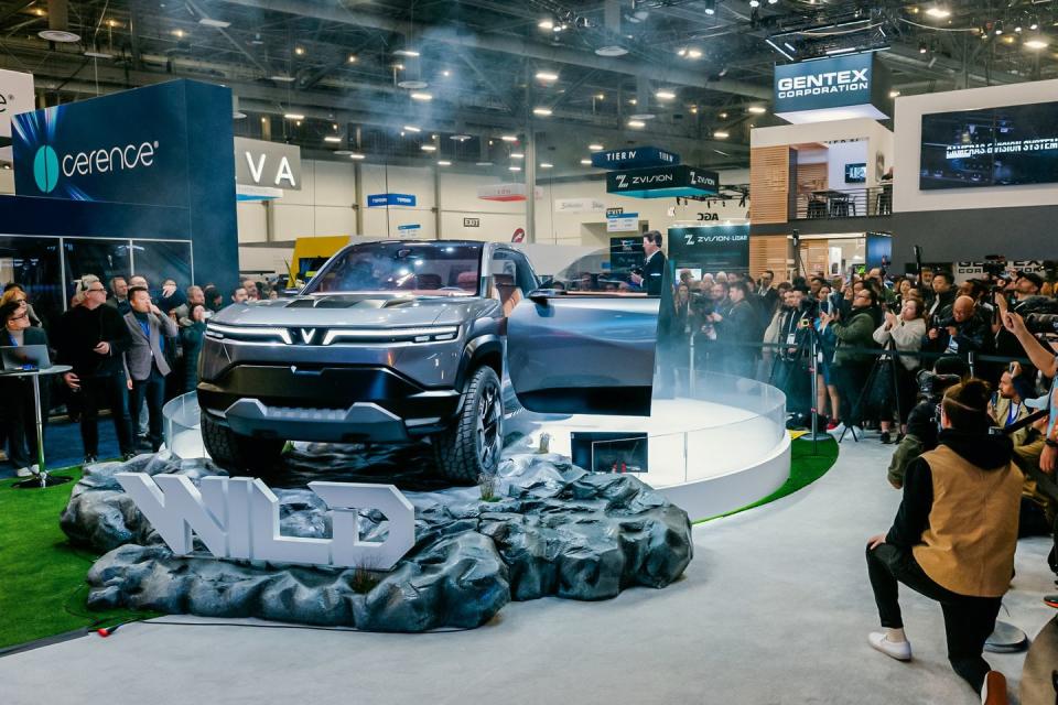 a car on display in a showroom with people around