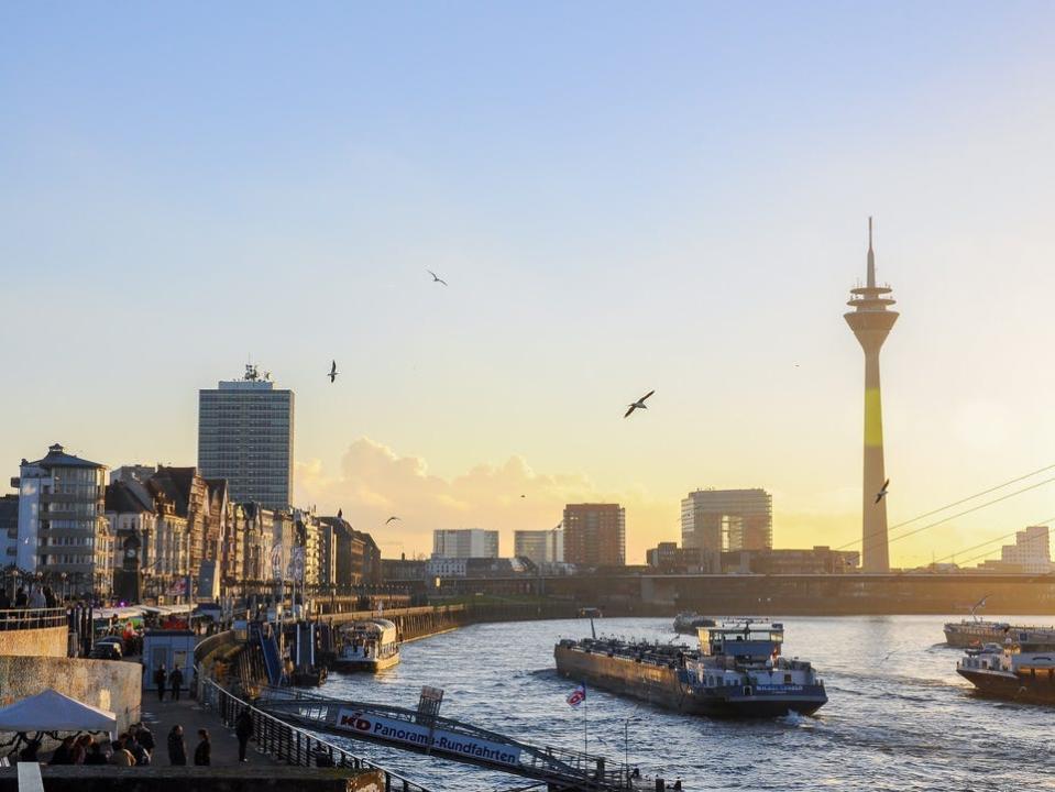 High Angle View Of Boats Sailing In Rhine River Against Rheinturm At Sunset