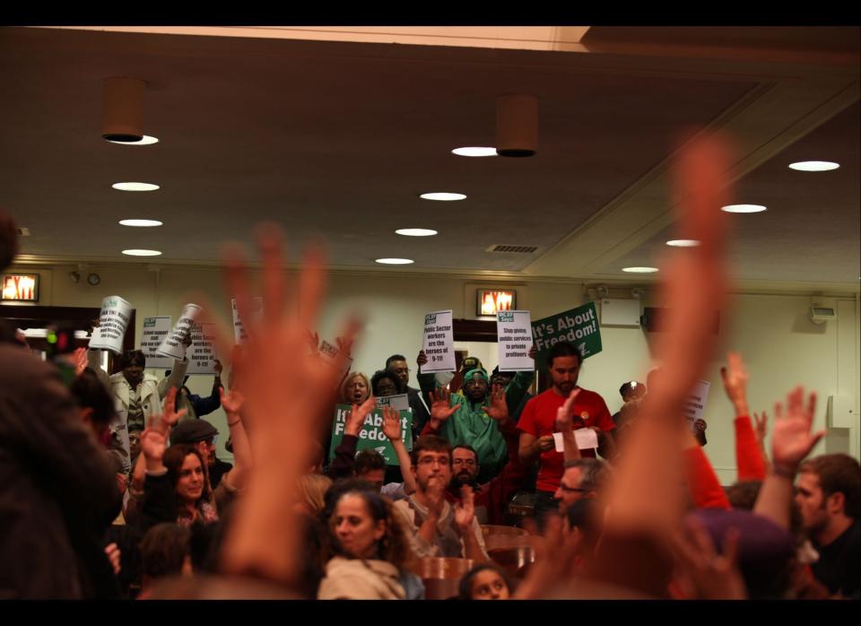 Hands go up in support of a speaker from Occupy Wall Street that took over the Mayor's panel for educational policy meeting at Seward High School, New York on Tuesday, October 26, 2011. (Myra Iqbal, AOL)