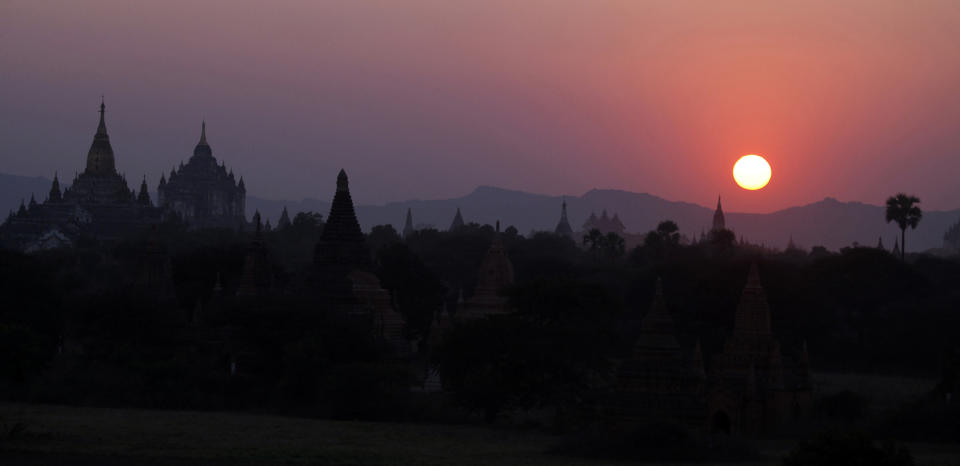 In this Jan. 25, 2013 photo, ancient temples stand during the sunset in Bagan, central Myanmar. After closing its doors to the West for half a century, Myanmar has reopened, inviting all to come and discover its treasures, ancient palaces of kings long gone, legends and mysteries told in stone. With ill-equipped roads and railways, there is no better way to explore than by river. Public ferries crisscross through glistening green paddies; old teak fishing boats can be rented by the day. (AP Photo/Khin Maung Win)