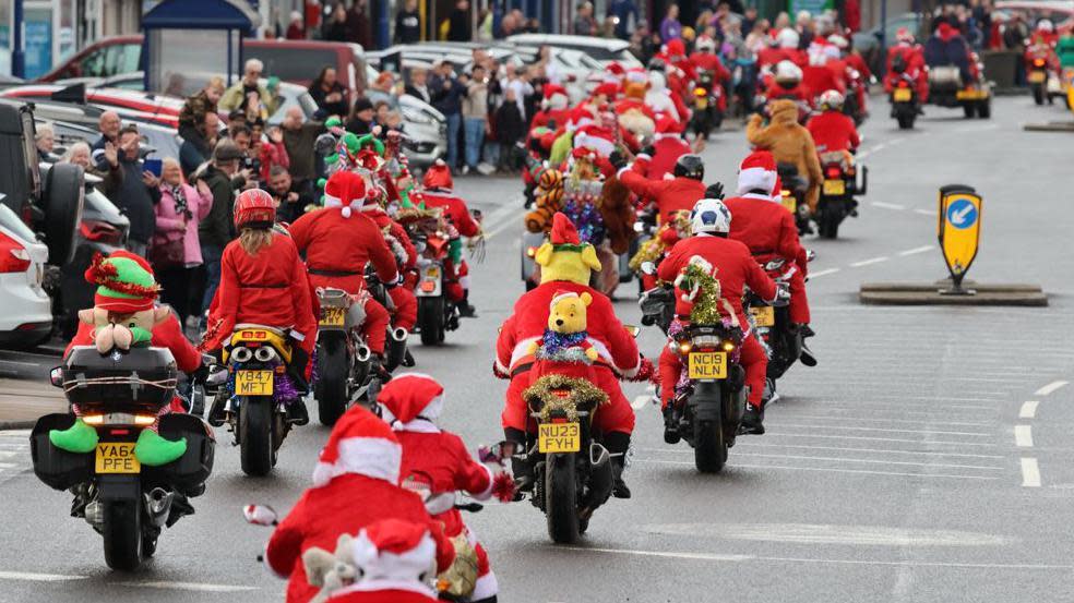Back view of a motorcyclists dressed as Santa Clause