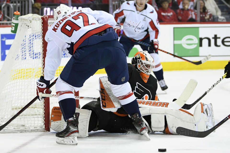 Philadelphia Flyers goaltender Brian Elliott (37) looks at the puck during the first period of an NHL hockey game against Washington Capitals center Evgeny Kuznetsov (92), of Russia, Sunday, March 24, 2019, in Washington. (AP Photo/Nick Wass)